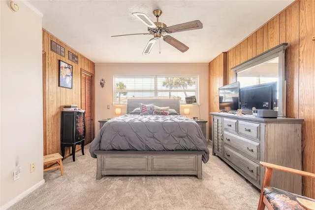 a spacious bedroom with a bed and a flat screen tv