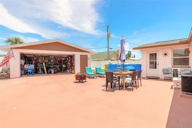 a view of a patio with a table and chairs under an umbrella with wooden fence