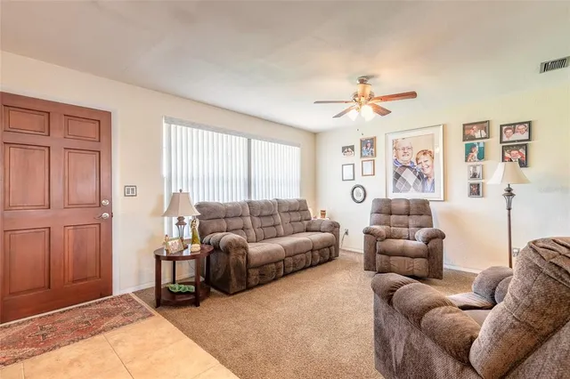 a living room with furniture ceiling fan and a window