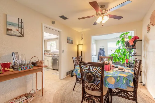a dining room with furniture potted plants and wooden floor