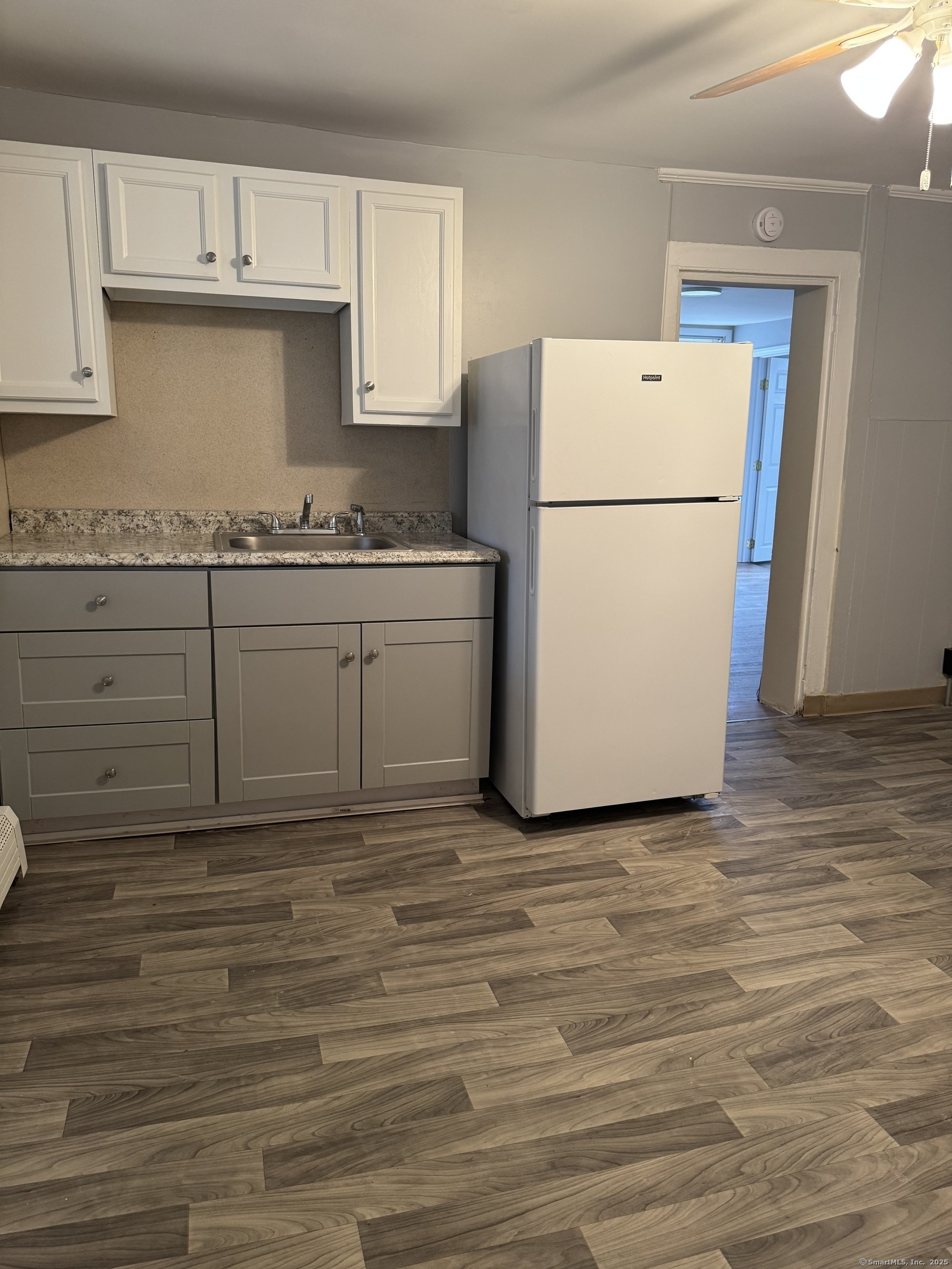 a kitchen with granite countertop a sink a stove a refrigerator and a cabinets
