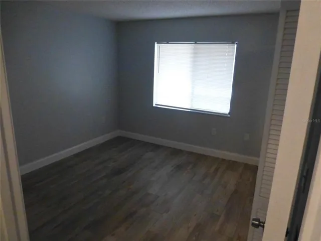 a view of a small space with wooden floor and a window