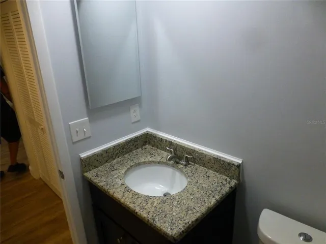 a bathroom with a granite countertop sink and a mirror