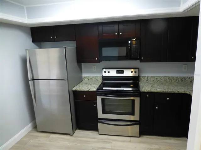 a kitchen with a refrigerator stove and cabinets