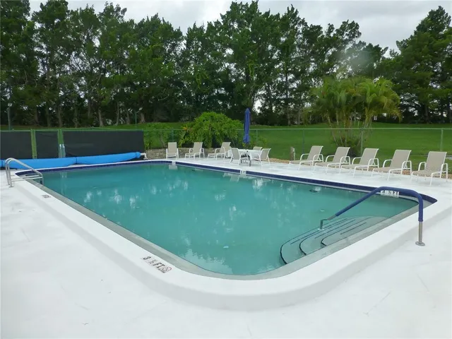 a view of a swimming pool with a garden and trees