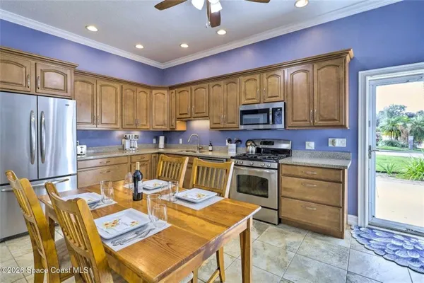 a kitchen with a appliances a stove a sink a refrigerator and a dining table with garden view