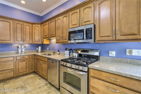 a kitchen with stainless steel appliances granite countertop a stove a sink and a microwave