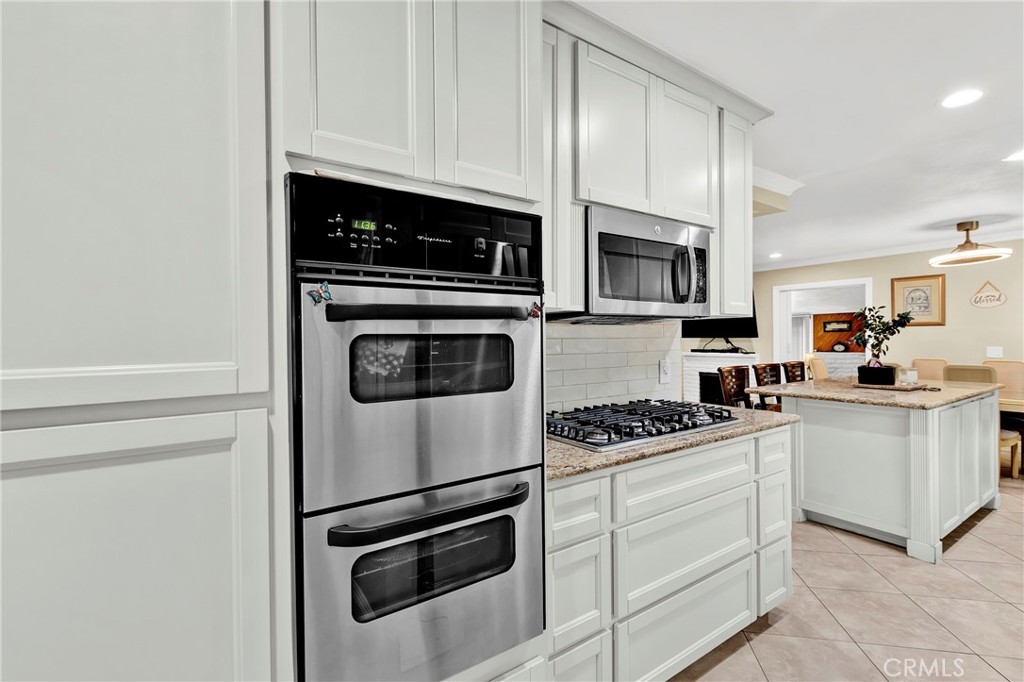 2501 Deodar Street Santa Ana, CA 92705 - Photo 13 of 43 a kitchen with granite countertop white cabinets and white appliances