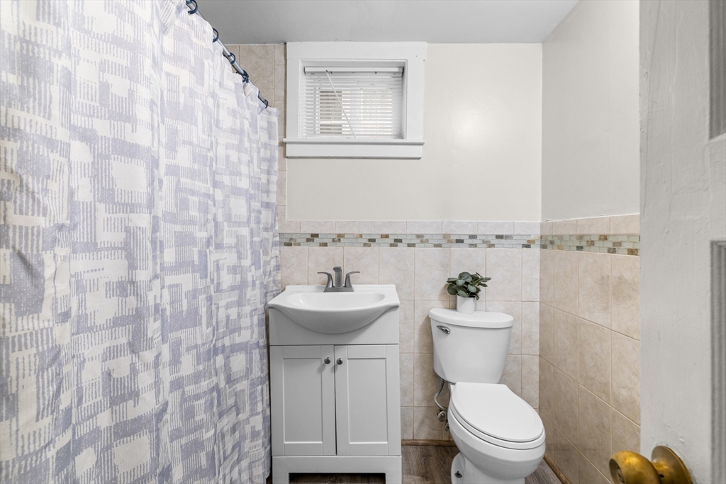 27 Brinsley Street, Unit 1 Boston, MA 02121 - Photo 12 of 16 a bathroom with a toilet sink and mirror
