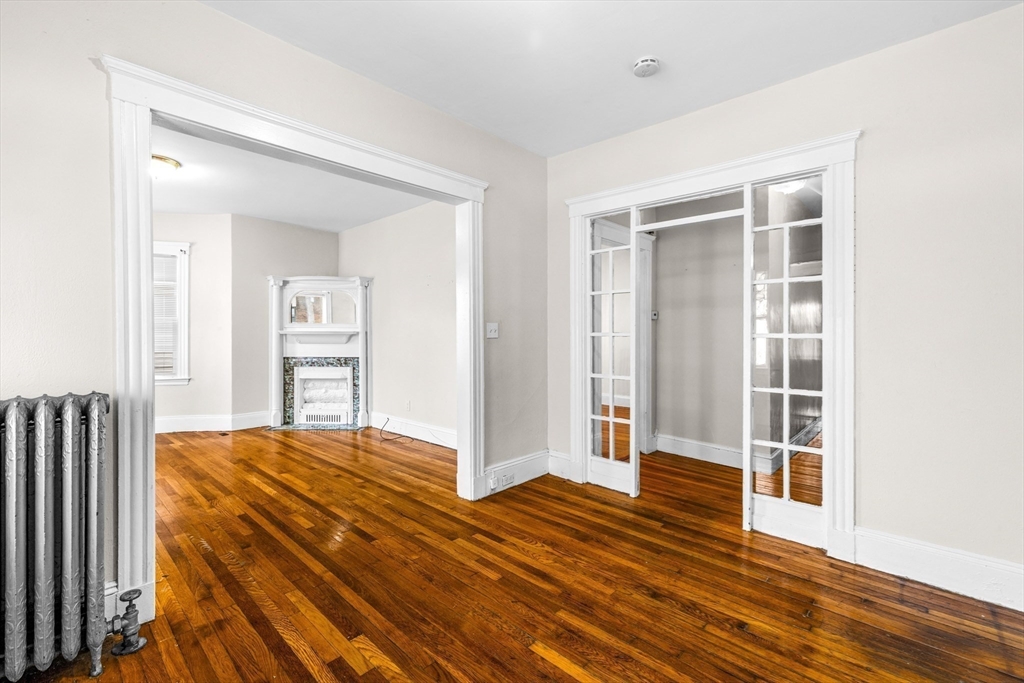 27 Brinsley Street, Unit 1 Boston, MA 02121 - Photo 2 of 16 a bedroom with a bed and wooden floor