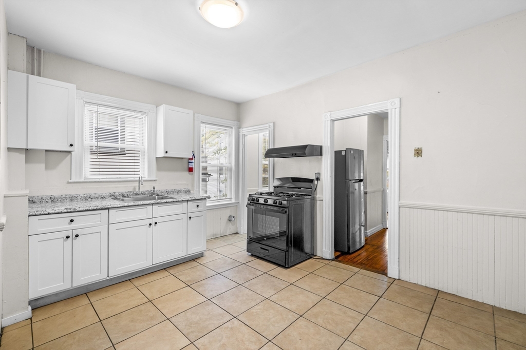 27 Brinsley Street, Unit 1 Boston, MA 02121 - Photo 8 of 16 a kitchen with stainless steel appliances granite countertop a refrigerator sink and stove