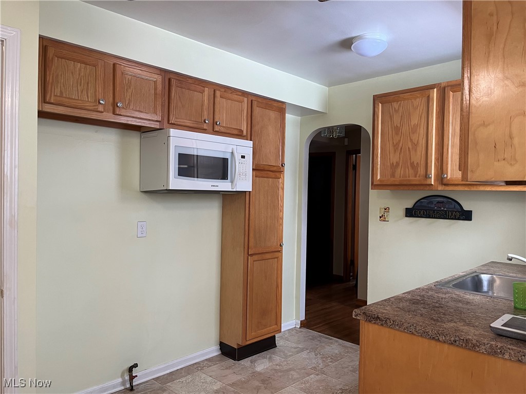 15405 Corkhill Road Maple Heights, OH 44137 - Photo 12 of 50 Kitchen with ston -like countertops, sink and microwave.