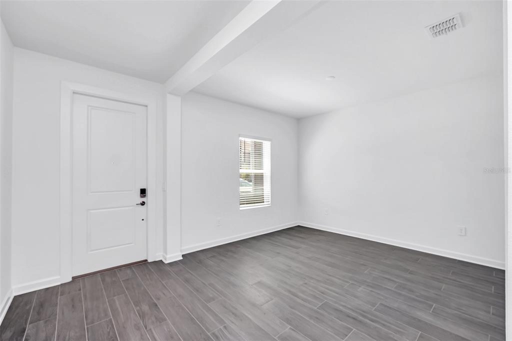 5768 Stephens Road St. Cloud, FL 34771 - Photo 4 of 50 a view of an empty room with wooden floor and a window