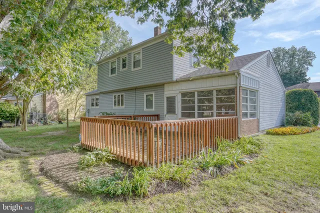 a view of a house with a yard and large tree