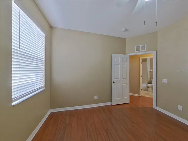 a view of an empty room with closet and a window