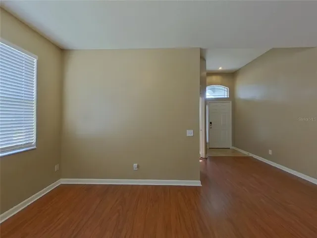 an empty room with wooden floor and closet
