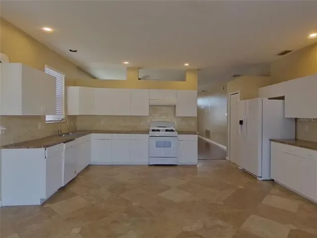 a large kitchen with a large window and stainless steel appliances