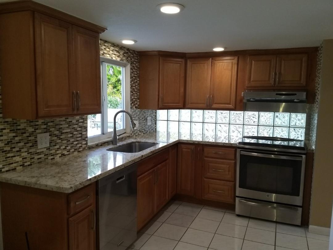 1031 Southwest 11th Street Boca Raton, FL 33486 - Photo 8 of 28 a kitchen with wooden cabinets and a stove top oven
