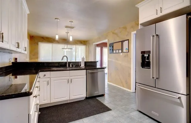 a kitchen with a refrigerator a sink and cabinets