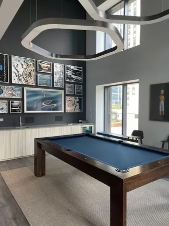 a room with pool table and windows