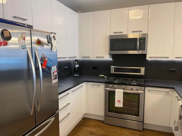 a kitchen with stainless steel appliances a stove microwave and sink