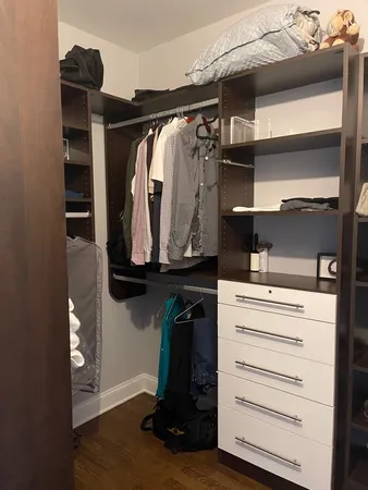 a view of walk in closet with clothes and shoes