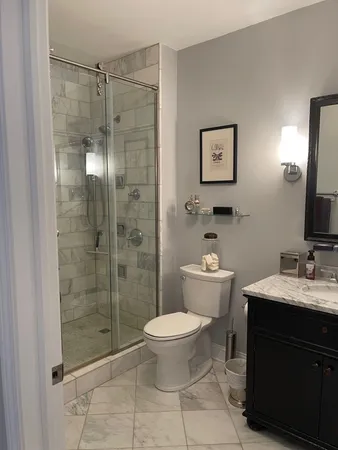 a bathroom with a granite countertop sink toilet and shower