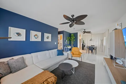 a living room with furniture kitchen view and a large window