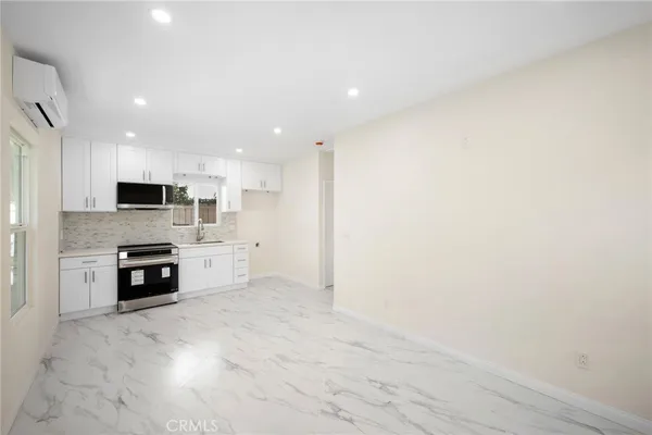 a kitchen with stainless steel appliances a stove top oven a sink and a refrigerator