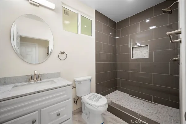 a bathroom with a sink a toilet and a mirror