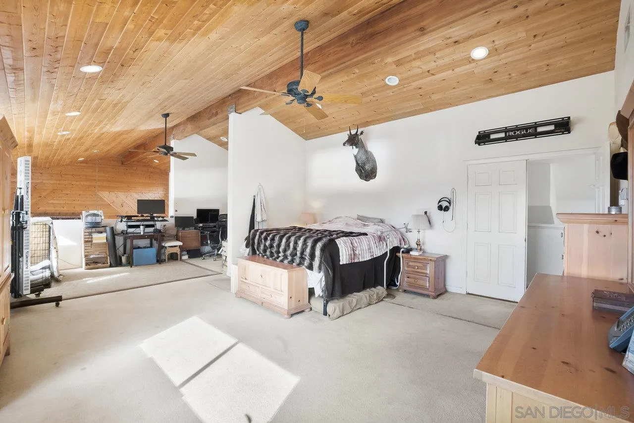 18995 Highway 94 Dulzura, CA 91917 - Photo 30 of 55 a spacious bedroom with a bed and a chandelier