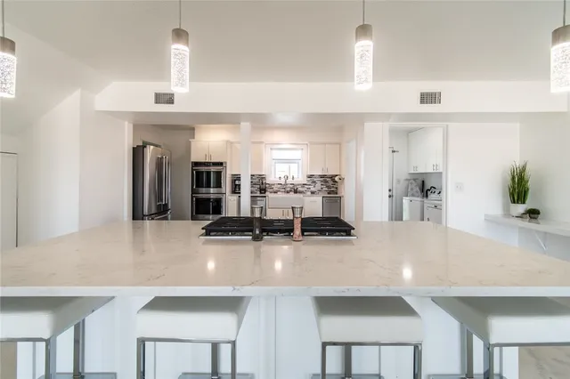 a kitchen with stainless steel appliances a sink and a refrigerator