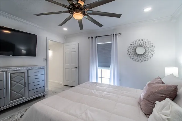 a bedroom with a bed and a ceiling fan