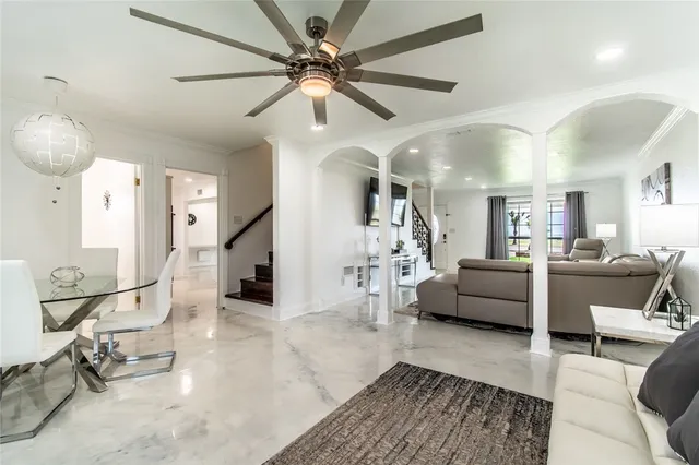 a living room with furniture and a view of kitchen