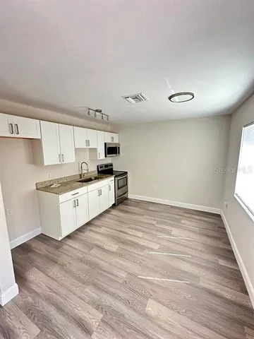 a large white kitchen with a stove top oven