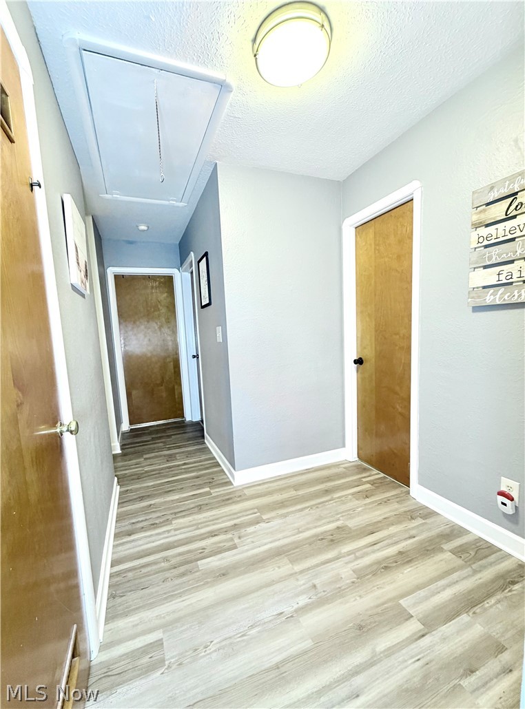 32125 Densmore Road Willowick, OH 44095 - Photo 15 of 23 Hallway featuring wood-finish flooring, light gray wall paint, white trim, and flush-mount ceiling lighting