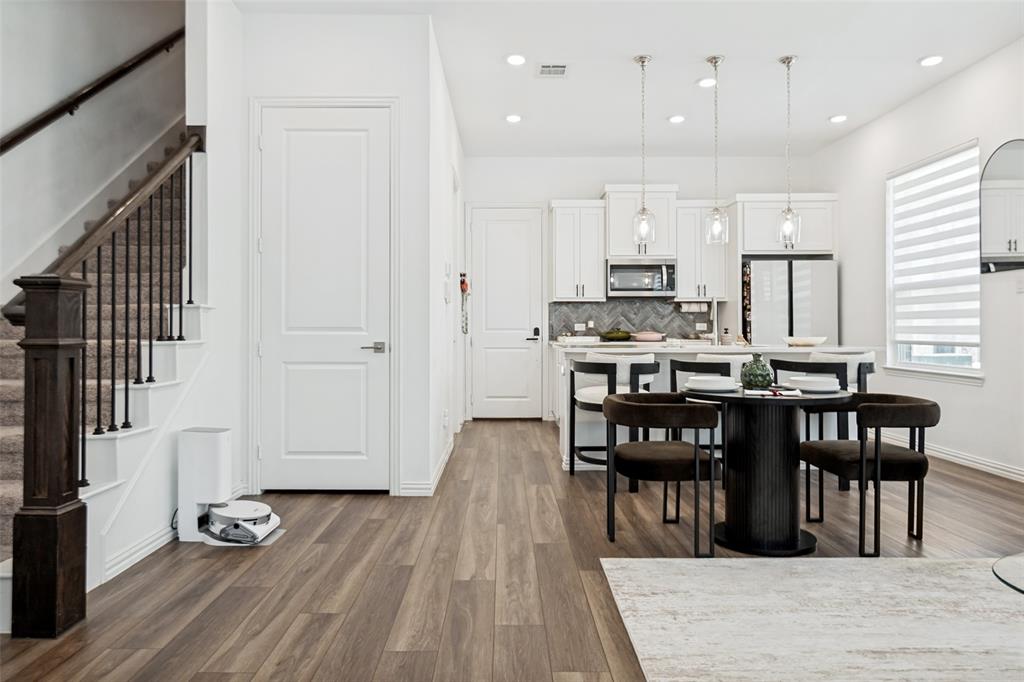 7536 Laburnam Road Dallas, TX 75228 - Photo 8 of 23 Open-concept living space with wood-finish flooring, a contemporary kitchen, white cabinetry, stainless steel appliances, and recessed lighting