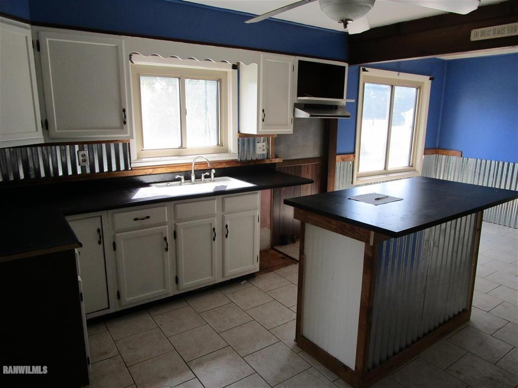 3636 Grove Road Pecatonica, IL 61063 - Photo 3 of 10 a kitchen that has a sink a microwave oven a stove and white cabinets