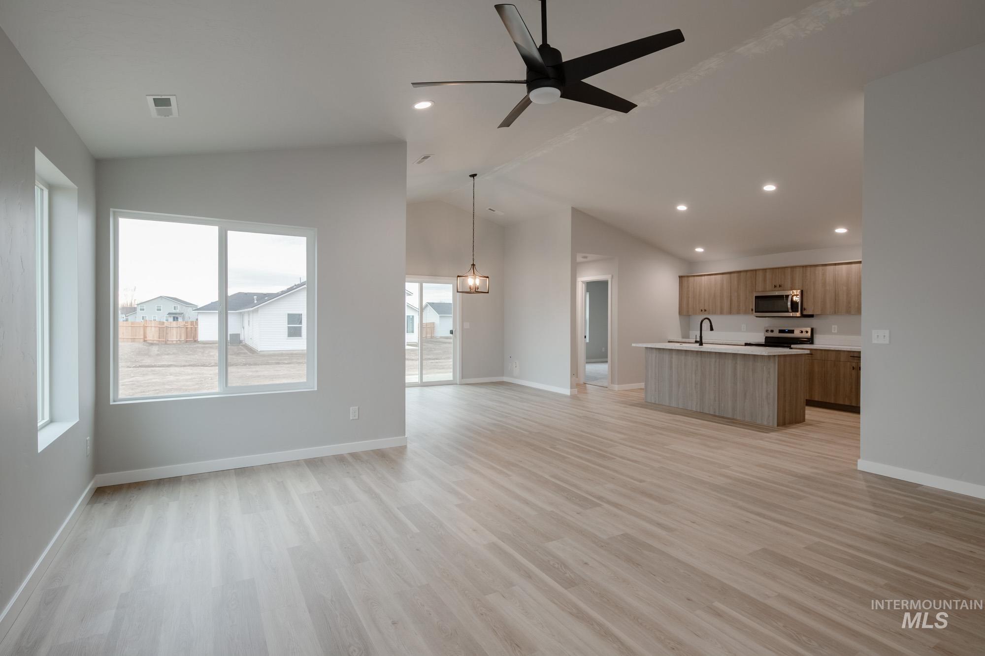 1631 Long Pond Street Middleton, ID 83644 - Photo 13 of 22 Unfurnished living room with recessed lighting, light wood finished floors, ceiling fan, and high vaulted ceiling