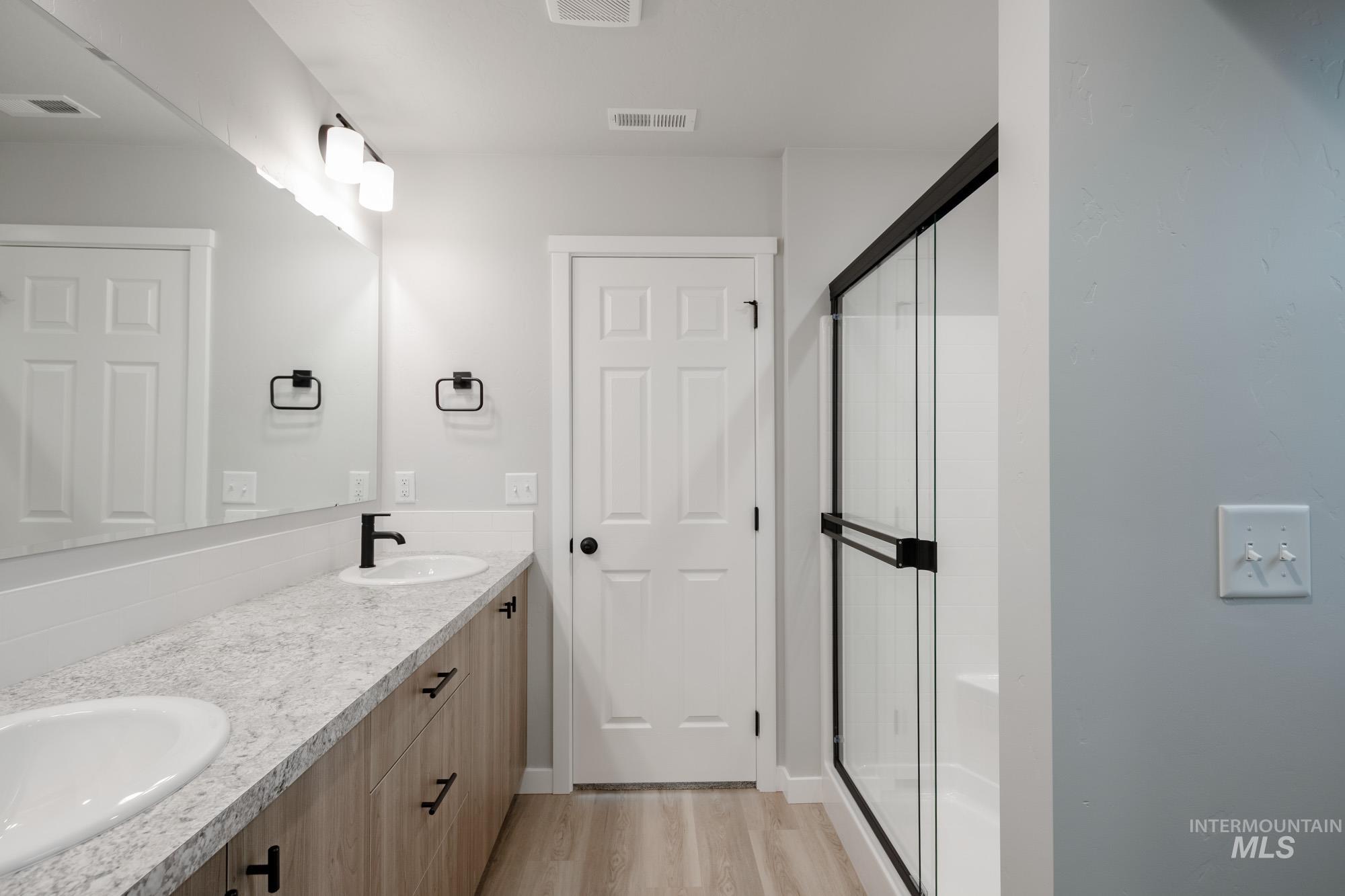1631 Long Pond Street Middleton, ID 83644 - Photo 22 of 22 Bathroom with double vanity, a stall shower, and light wood-style flooring