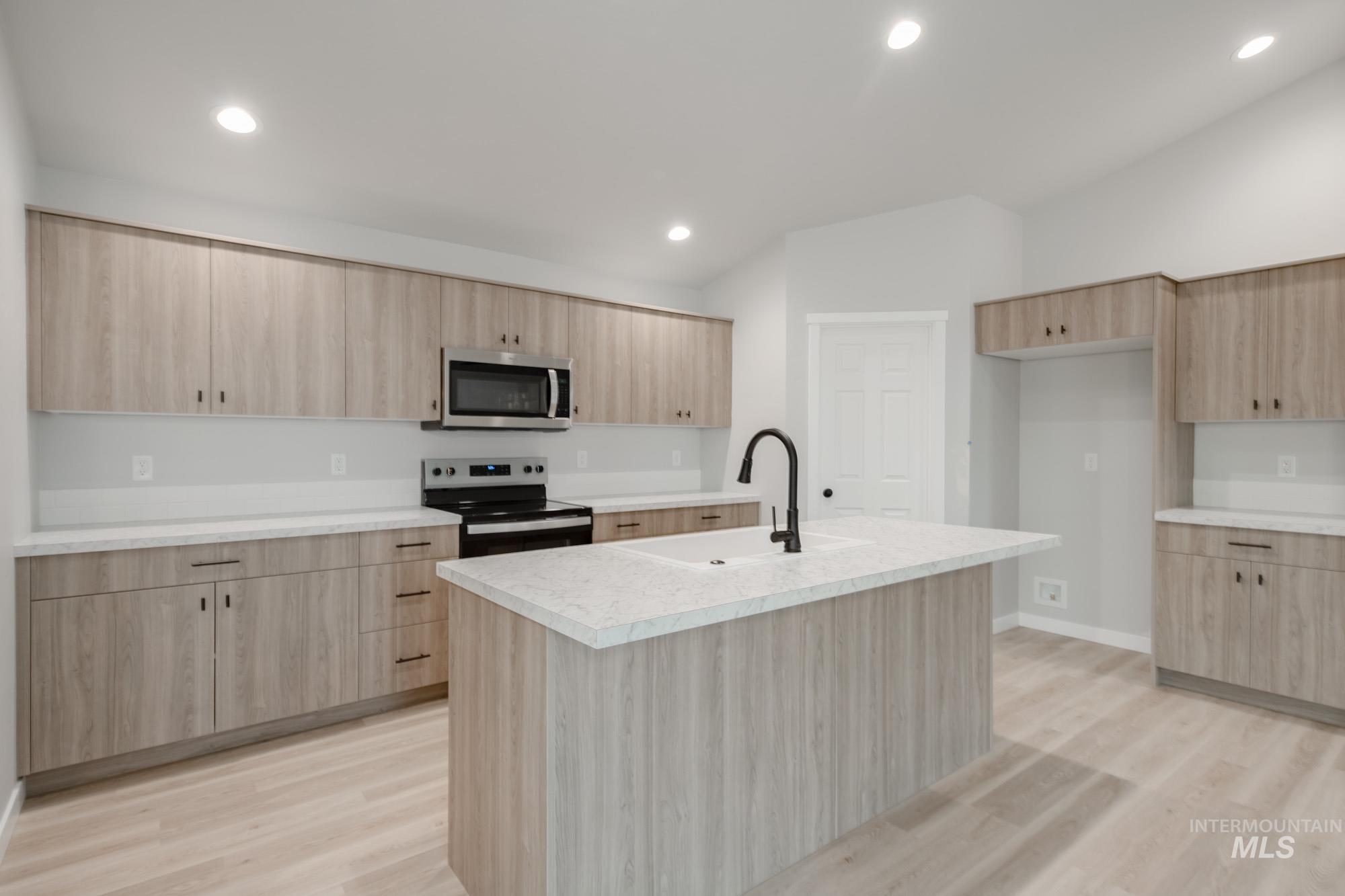 1631 Long Pond Street Middleton, ID 83644 - Photo 5 of 22 Kitchen featuring range with electric cooktop, light wood finished floors, light countertops, light brown cabinetry, and recessed lighting