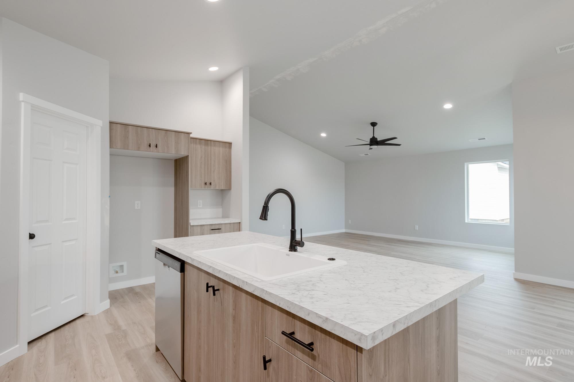 1631 Long Pond Street Middleton, ID 83644 - Photo 7 of 22 Kitchen featuring light brown cabinetry, light wood-style flooring, lofted ceiling, light countertops, and dishwasher