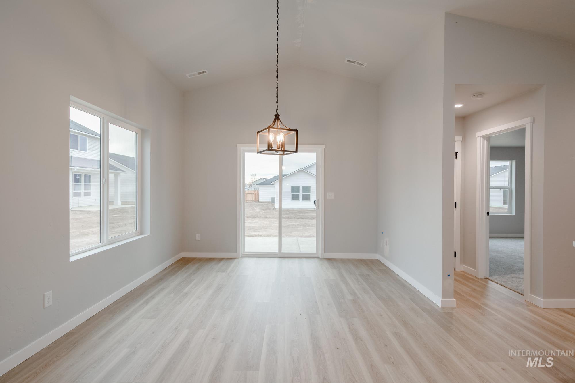 1631 Long Pond Street Middleton, ID 83644 - Photo 9 of 22 Unfurnished dining area with vaulted ceiling, plenty of natural light, and light wood-style floors
