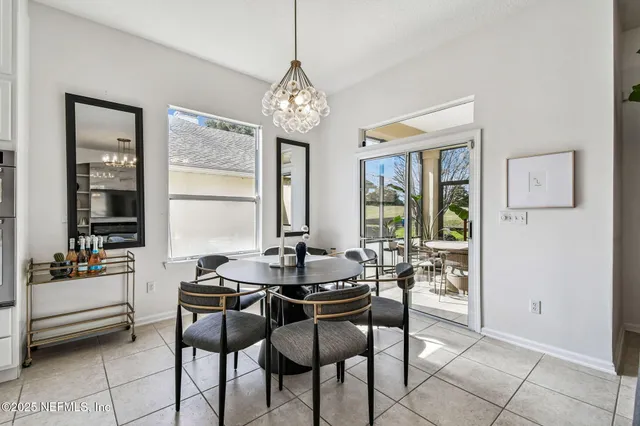 a dining room with furniture a chandelier and window