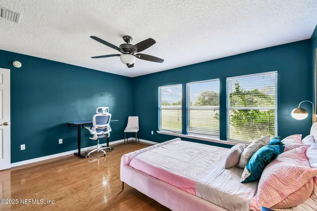 a bedroom with a bed desk and a window
