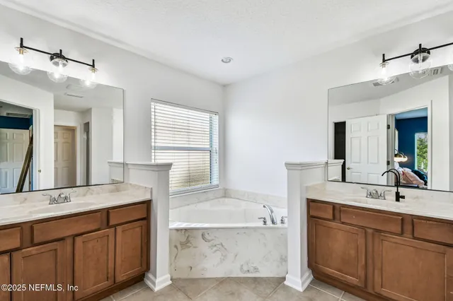 a bathroom with a granite countertop double vanity sink mirror and