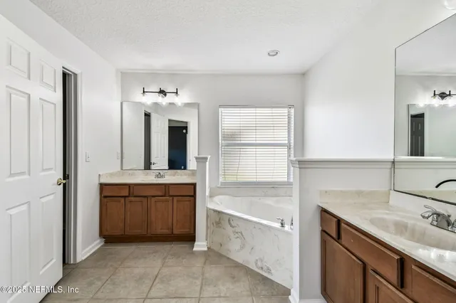 a spacious bathroom with a granite countertop tub sink and mirror