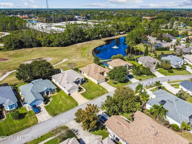 a view of a water fountain with potted plants in front of it