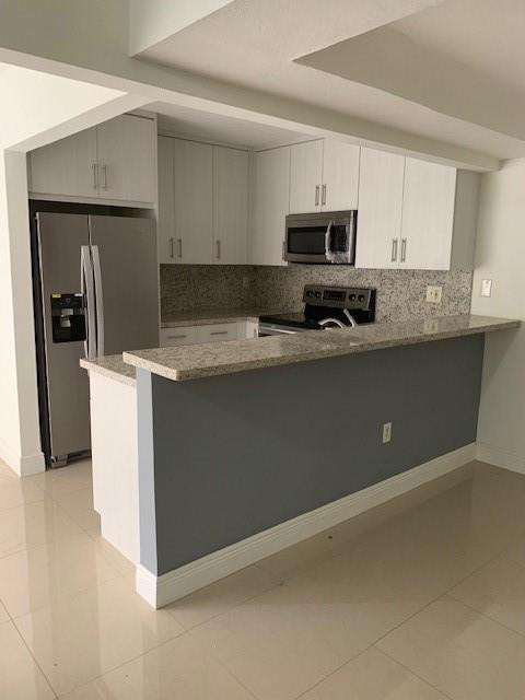 1950 Southwest 121st Court, Unit 240 Miami, FL 33175 - Photo 1 of 27 a kitchen with stainless steel appliances granite countertop a stove a sink and a refrigerator