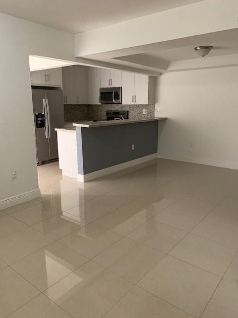 1950 Southwest 121st Court, Unit 240 Miami, FL 33175 - Photo 13 of 27 a kitchen with stainless steel appliances a sink a stove a microwave a counter top space and cabinets